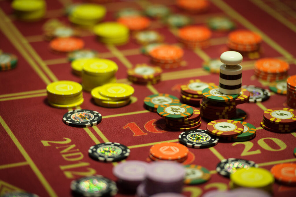 Close up of a roulette table's racetrack with casino chips on it.