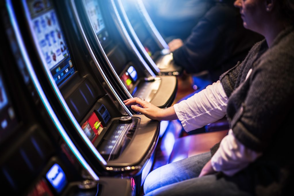 A photo of a person playing a slot machine in a casino.