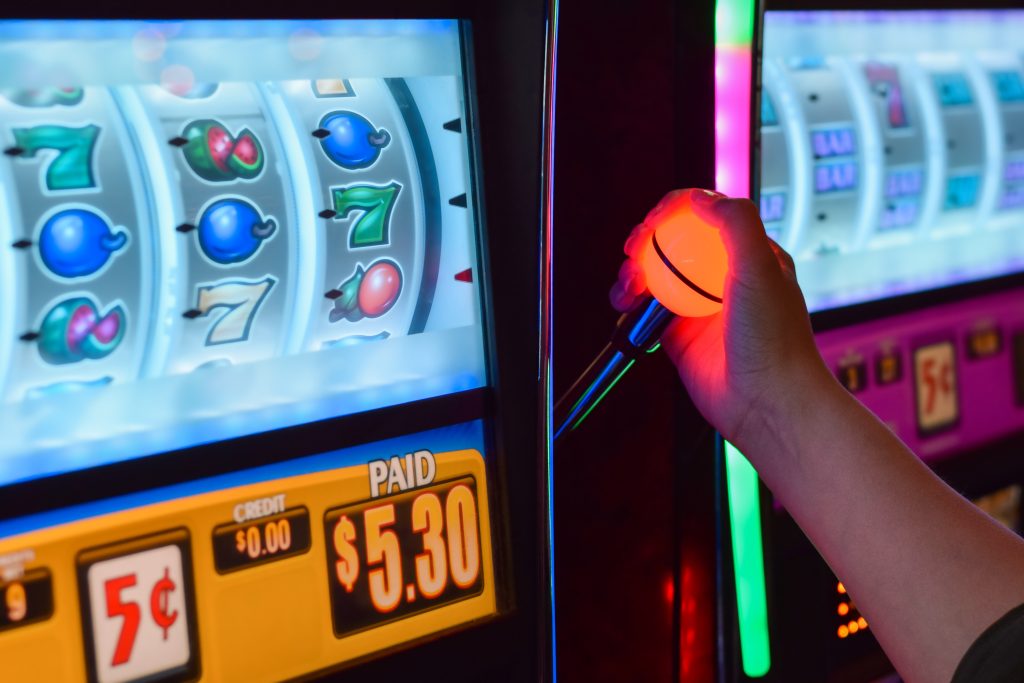A photo of a person playing a slot machine in a casino.