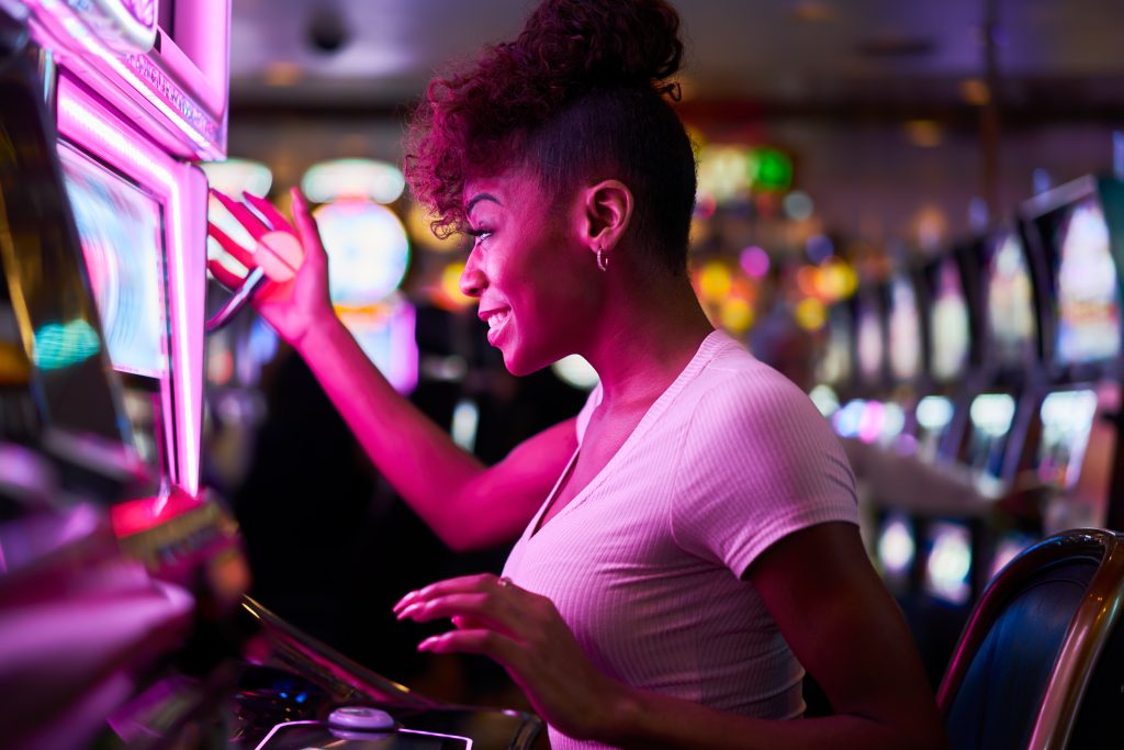 A woman playing a slot machine in a casino.