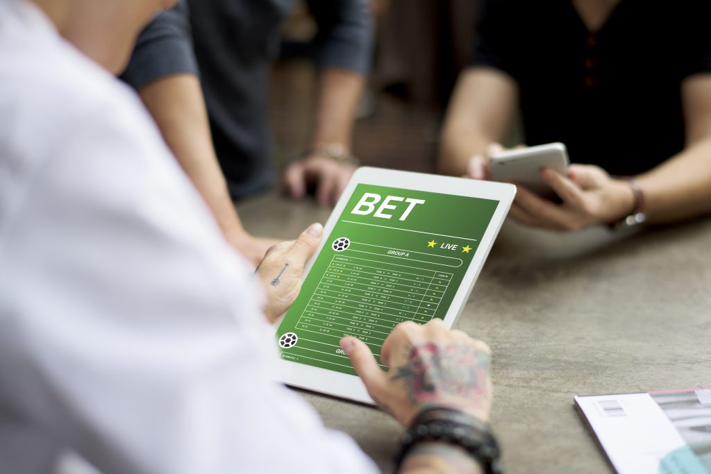 A photo of a person using a tablet to place a bet.
