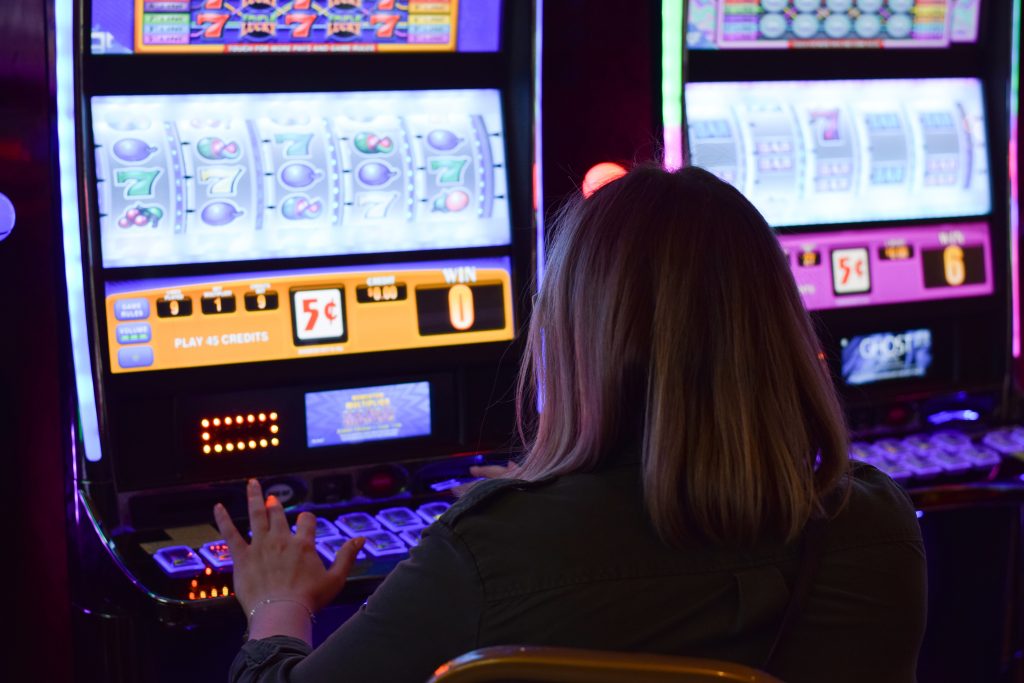 A photo of a woman playing a slot machine.