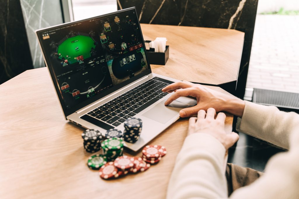 A photo of a person playing online poker on a laptop.