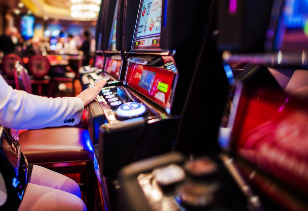 A photo of a person playing a slot machine in a casino.