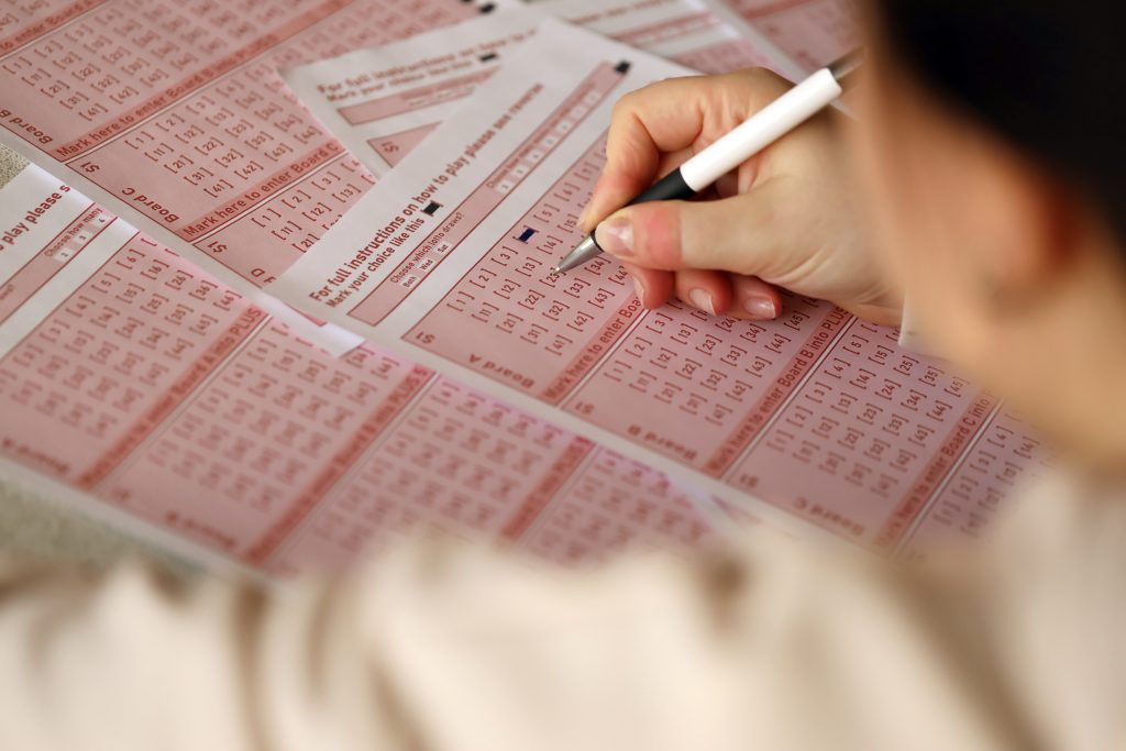 A photo of a person filling in a lottery ticket.