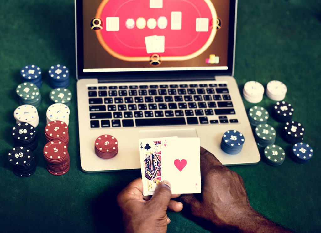 A photo of a person playing poker online on a laptop.