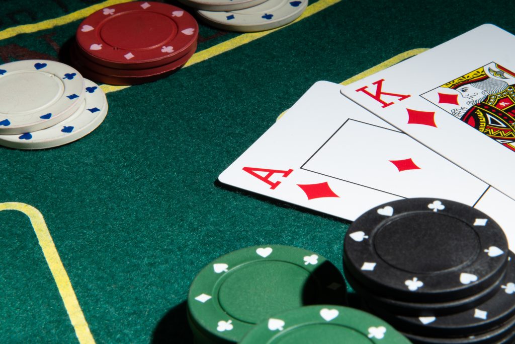 A photo of a King and Ace playing cards on a blackjack table next to casino chips.