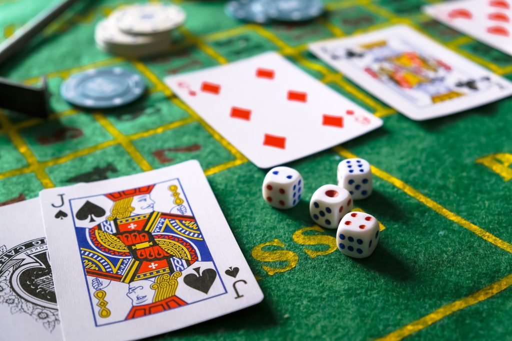 A photo of playing cards, casino chips and dice.