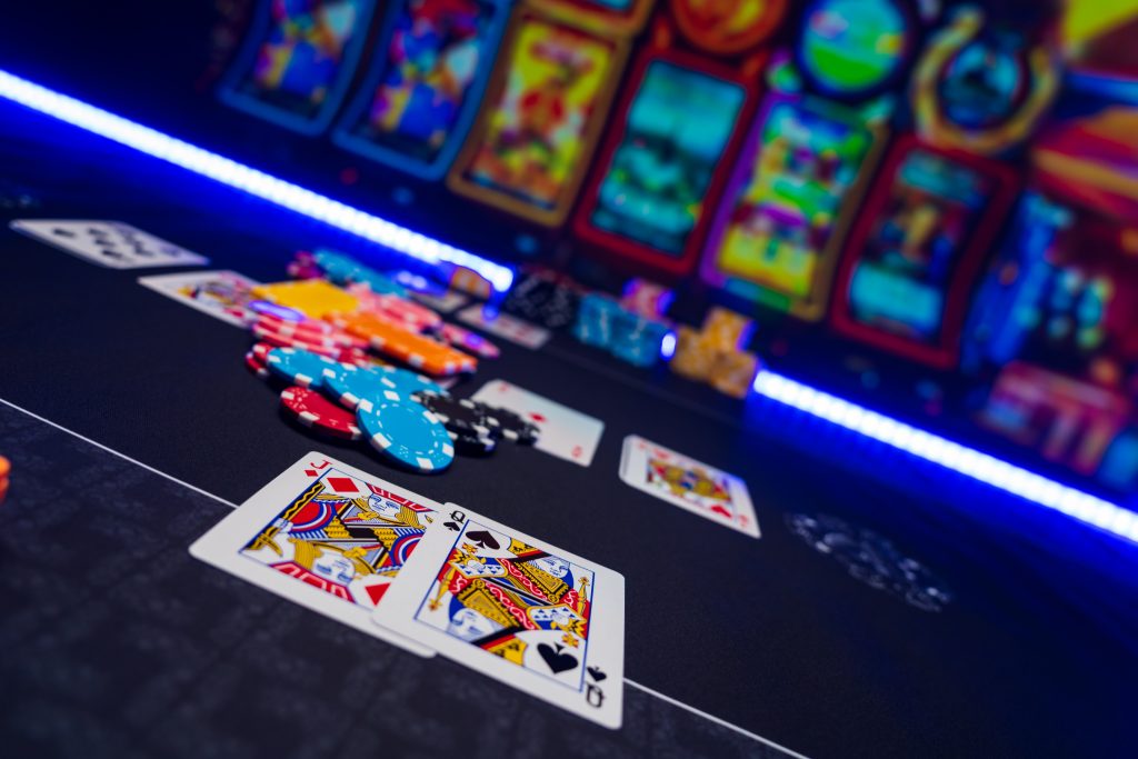A photo of slot machines, casino chips and playing cards in a casino.