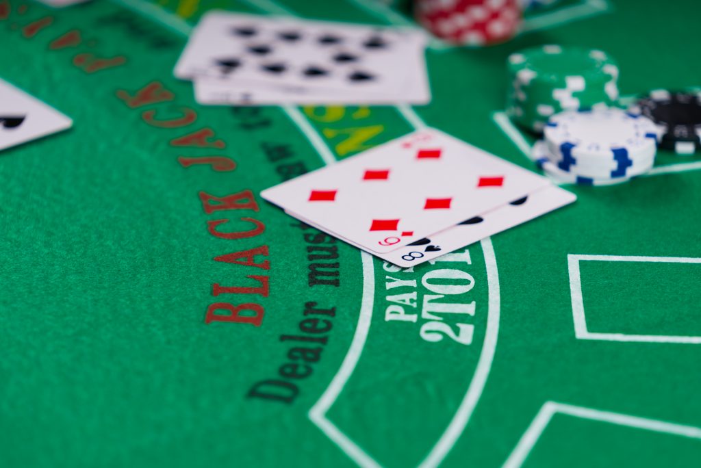 A photo of playing cards and casino chips on a blackjack table.