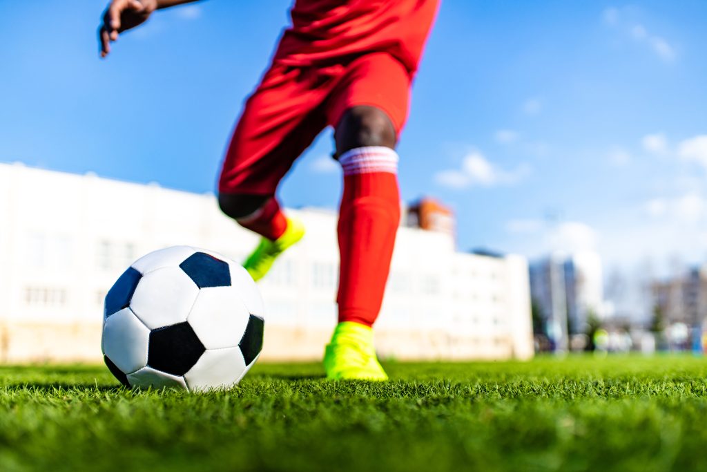 A photo of a football player kicking the ball.