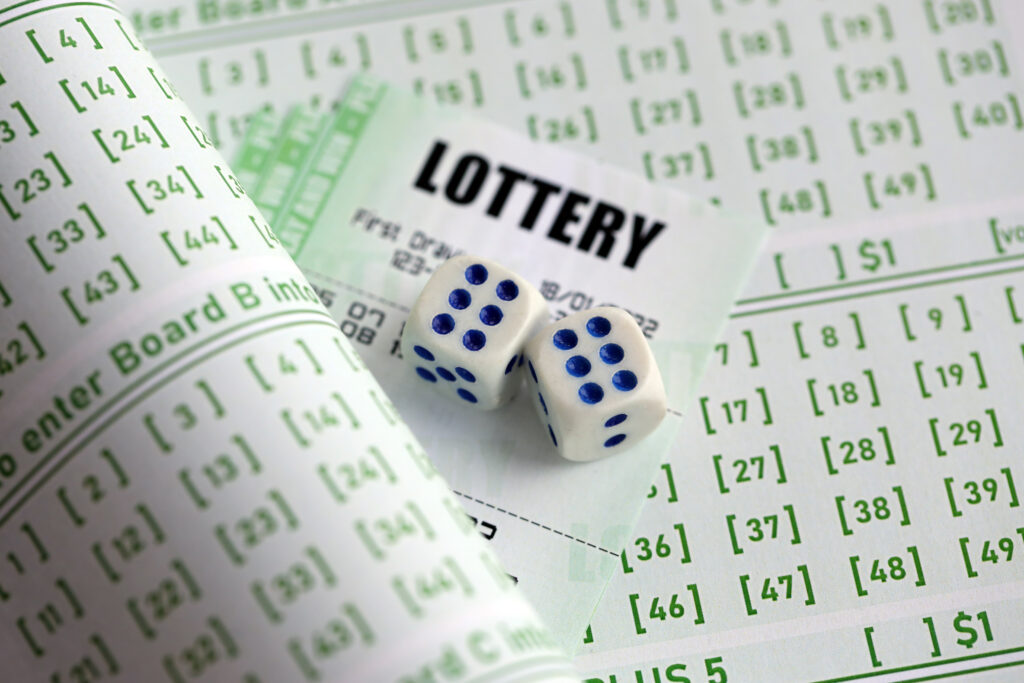 Close up of lottery tickets and dice on blank bills with numbers for playing the lottery.