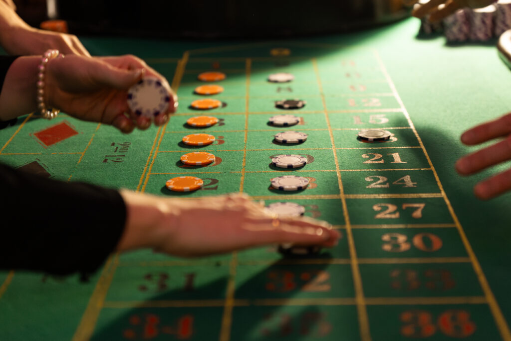 People placing bets on a roulette racetrack.