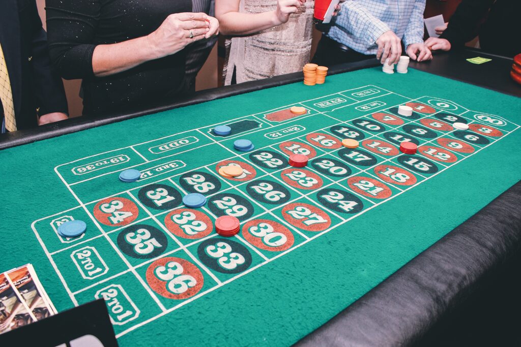 People placing bets on a roulette table.